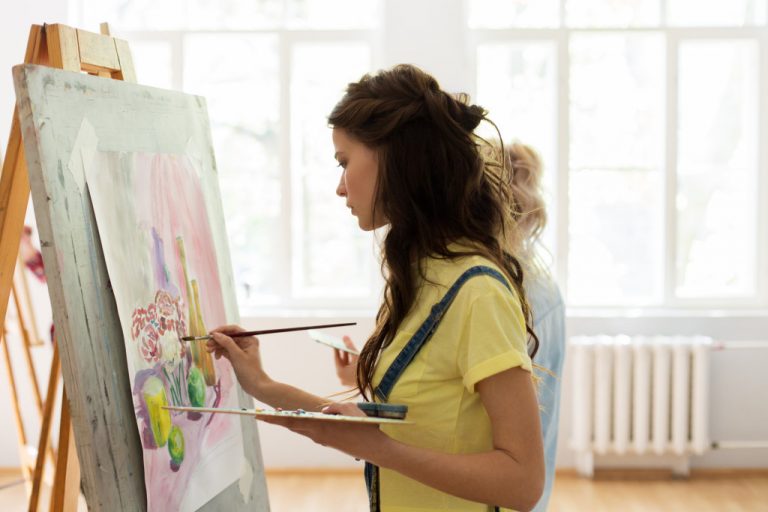 young girl painting with easel